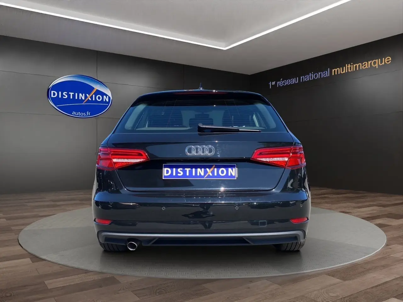 Vue arrière d'une Audi A3 Sportback noire 2020 avec feux arrière LED et sortie d'échappement unique visible.