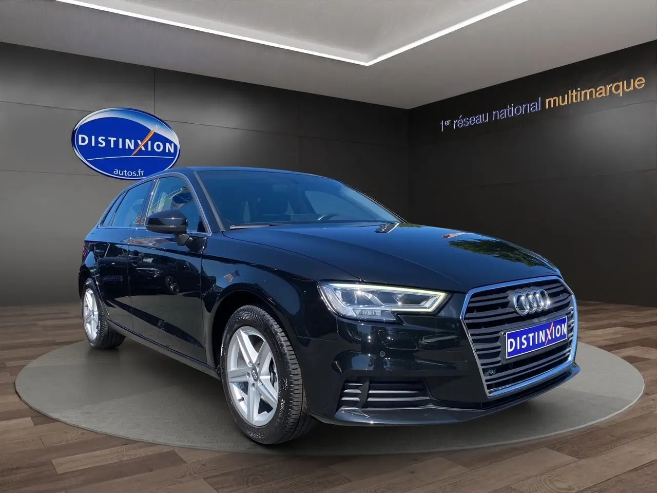 Audi A3 Sportback noire vue en 3/4 avant droit, avec projecteurs LED et jantes alliage 5 branches.
