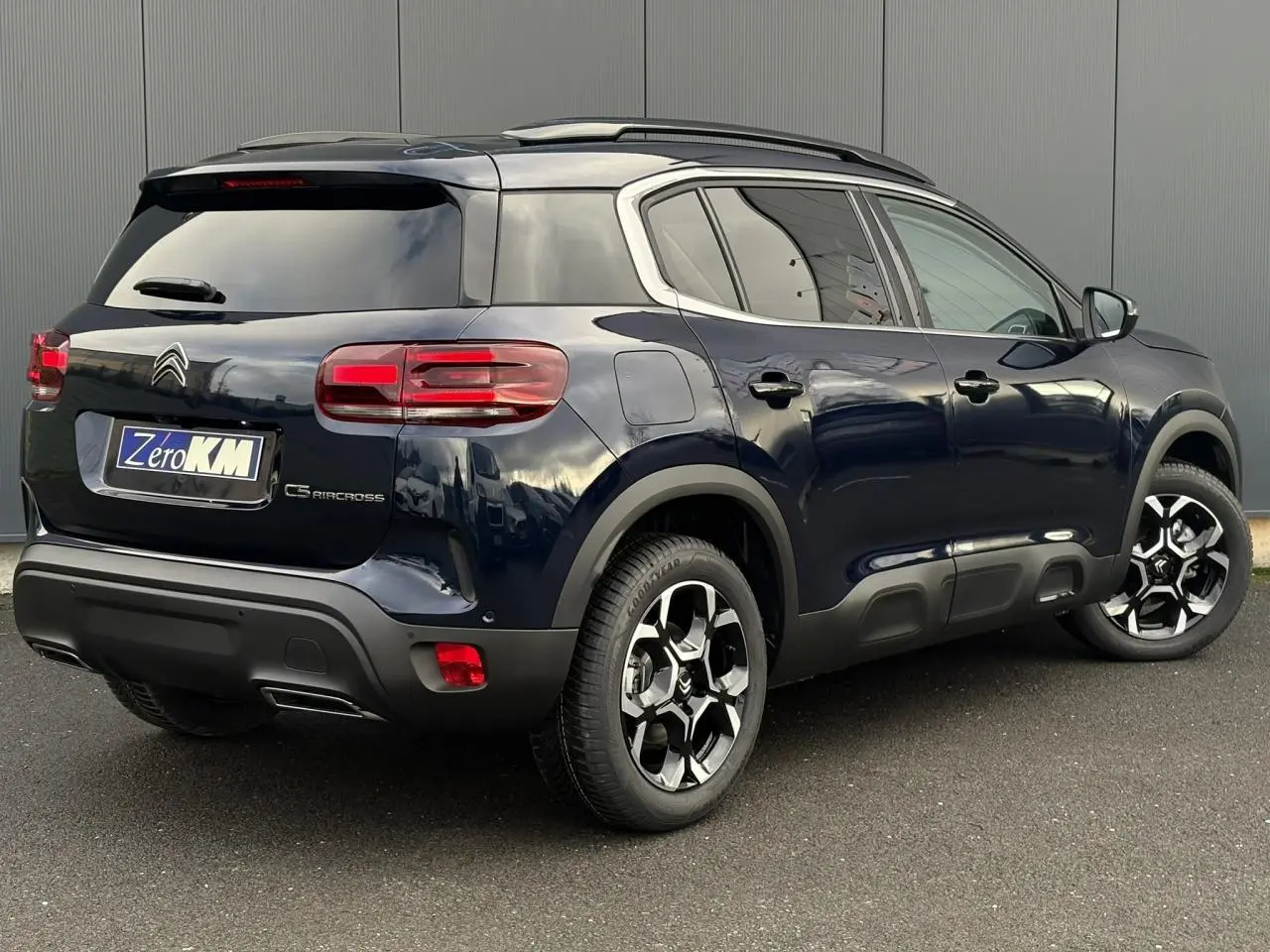 Vue 3/4 arrière droit d'un Citroën C5 Aircross Bleu Eclipse avec toit noir et jantes alliage bi-ton.