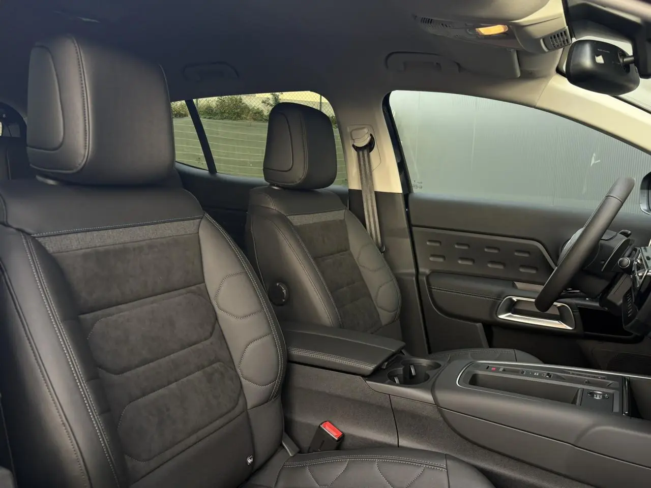 Vue intérieure côté conducteur du Citroën C5 Aircross 2025, sièges Urban Black en Alcantara et cuir noir avec surpiqûres bleues.