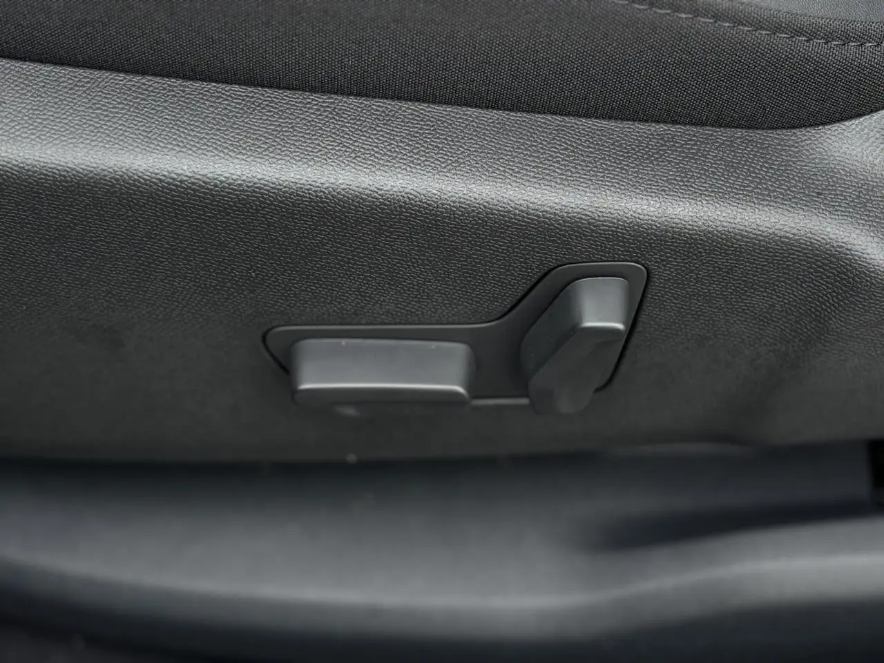 Gros plan sur les commandes électriques de réglage du siège avant dans un Citroën C5 Aircross 2025 finition Urban Black.