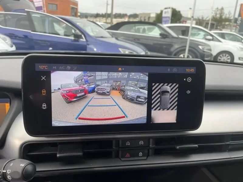 Vue arrière en caméra de recul d'une Jeep Avenger gris métal 2025, avec lignes de guidage de stationnement visibles.