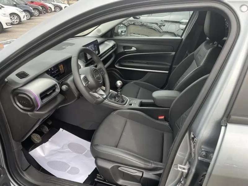 Intérieur côté conducteur du Jeep Avenger gris métal 2025, avec volant, tableau de bord numérique et boîte manuelle visible.
