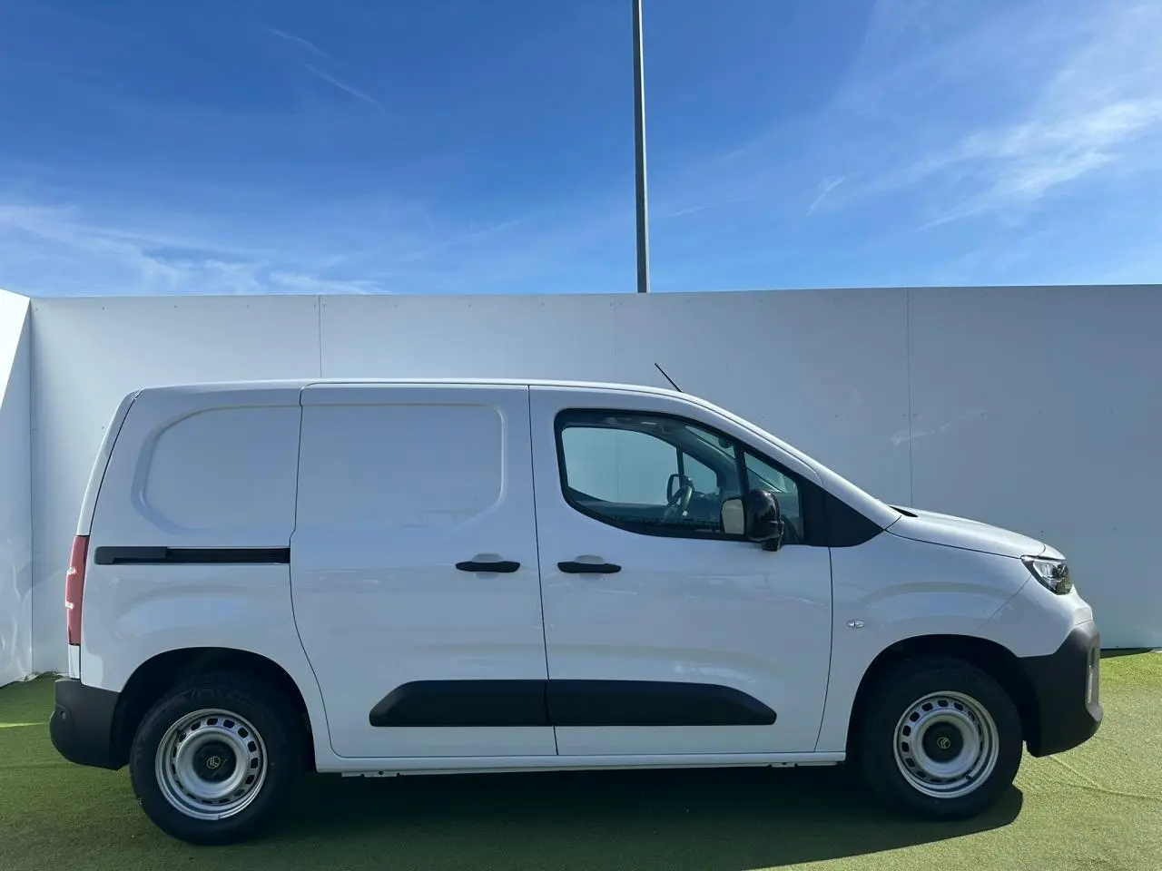 Profil droit d'un utilitaire Citroën Berlingo III blanc Icy avec portes coulissante et battantes, roues tôles grises.