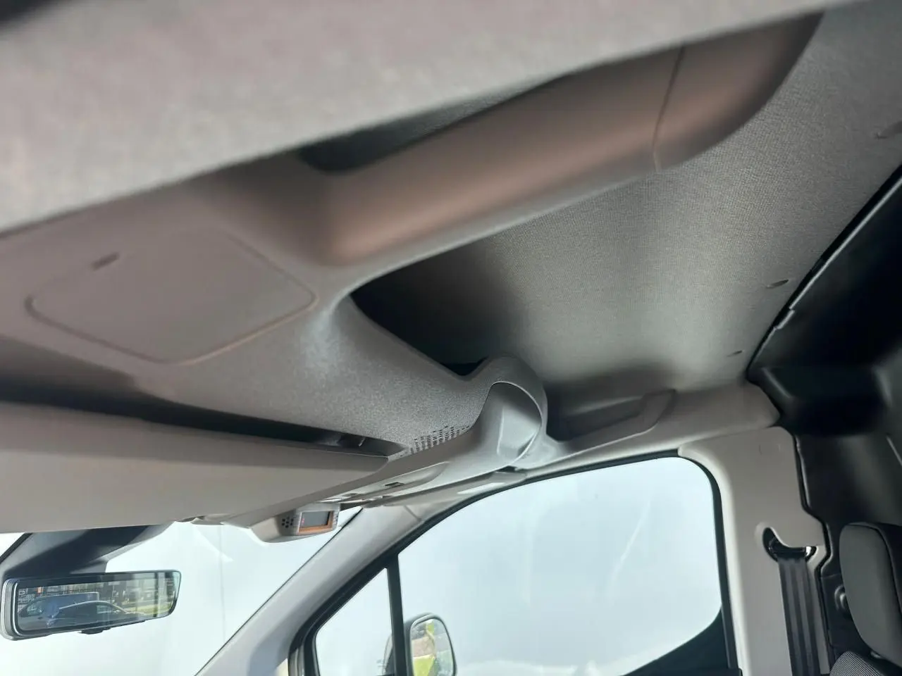 Vue intérieure du toit et pare-brise côté conducteur du Citroën Berlingo blanc avec rétroviseur numérique.