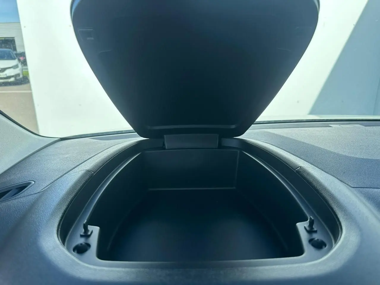 Coffre de rangement ouvert sur planche de bord noire dans l'habitacle d'un Citroën Berlingo blanc Icy.