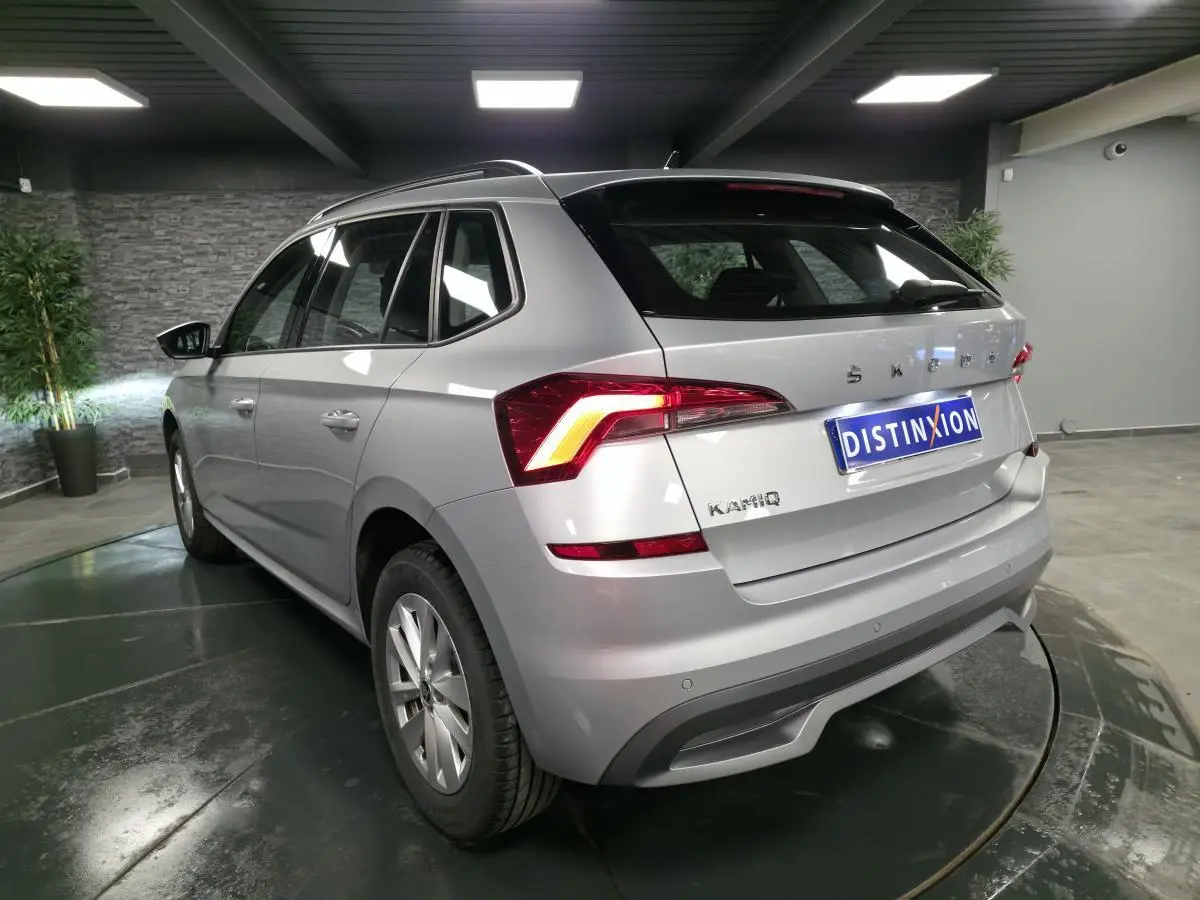 Vue 3/4 arrière droite d'un Skoda Kamiq gris métallisé avec feux arrière LED et jantes alliage 16 pouces.