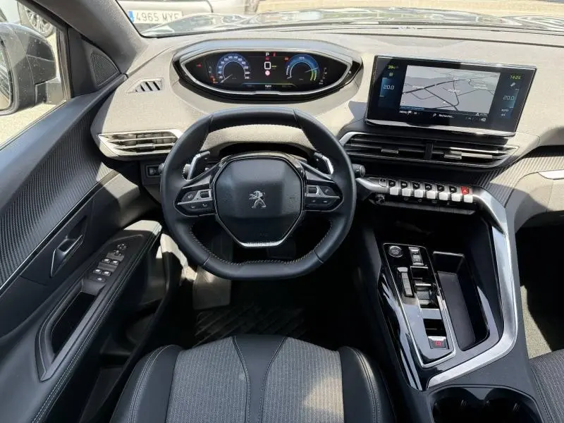 Vue intérieure avant du Peugeot 3008 Hybride Rechargeable noir, volant cuir multifonction et écran tactile central.
