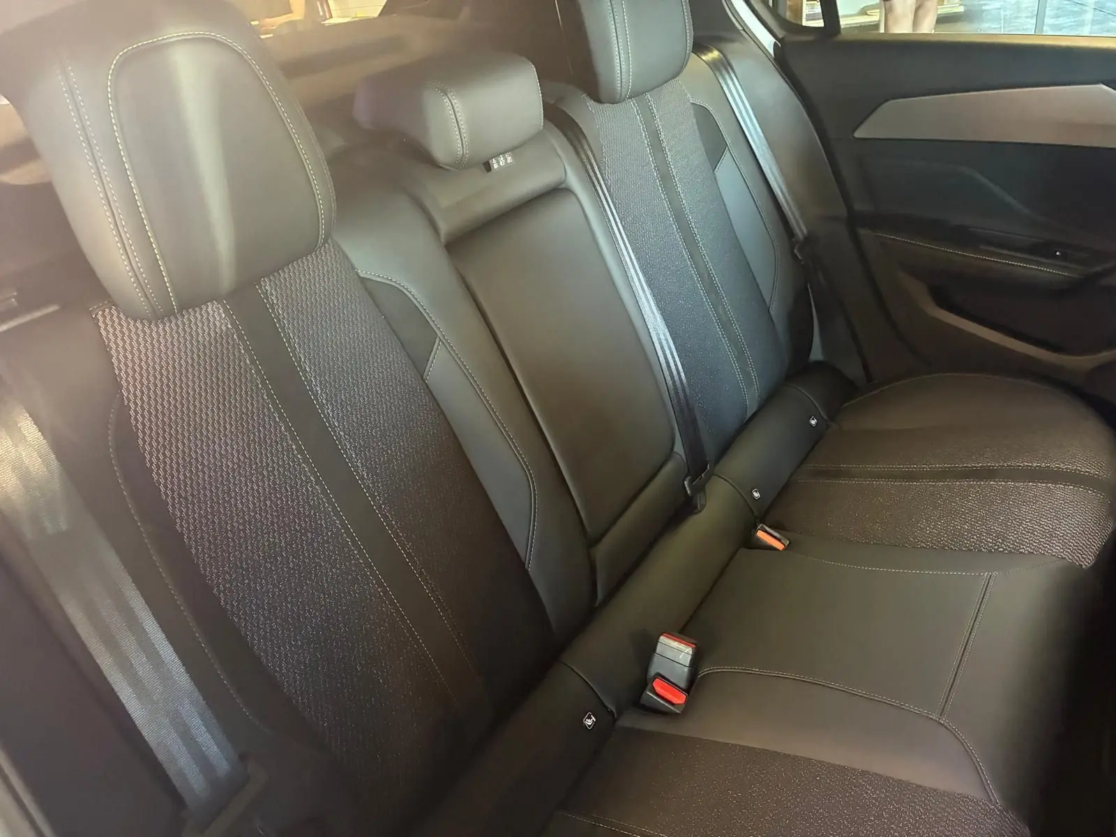 Vue intérieure montrant la banquette arrière noire de la Peugeot 308 1.2 Hybrid 136 E-DCS6 GT de 2025.