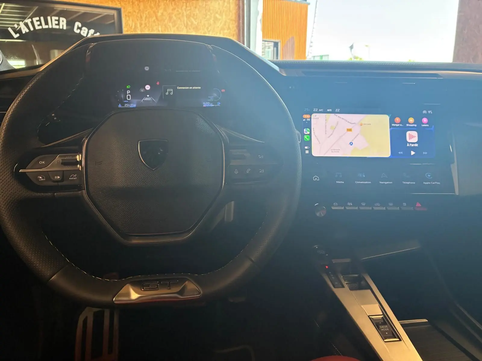Vue intérieure centrée sur le volant noir de la Peugeot 308 GT avec écran tactile et affichage numérique lumineux.