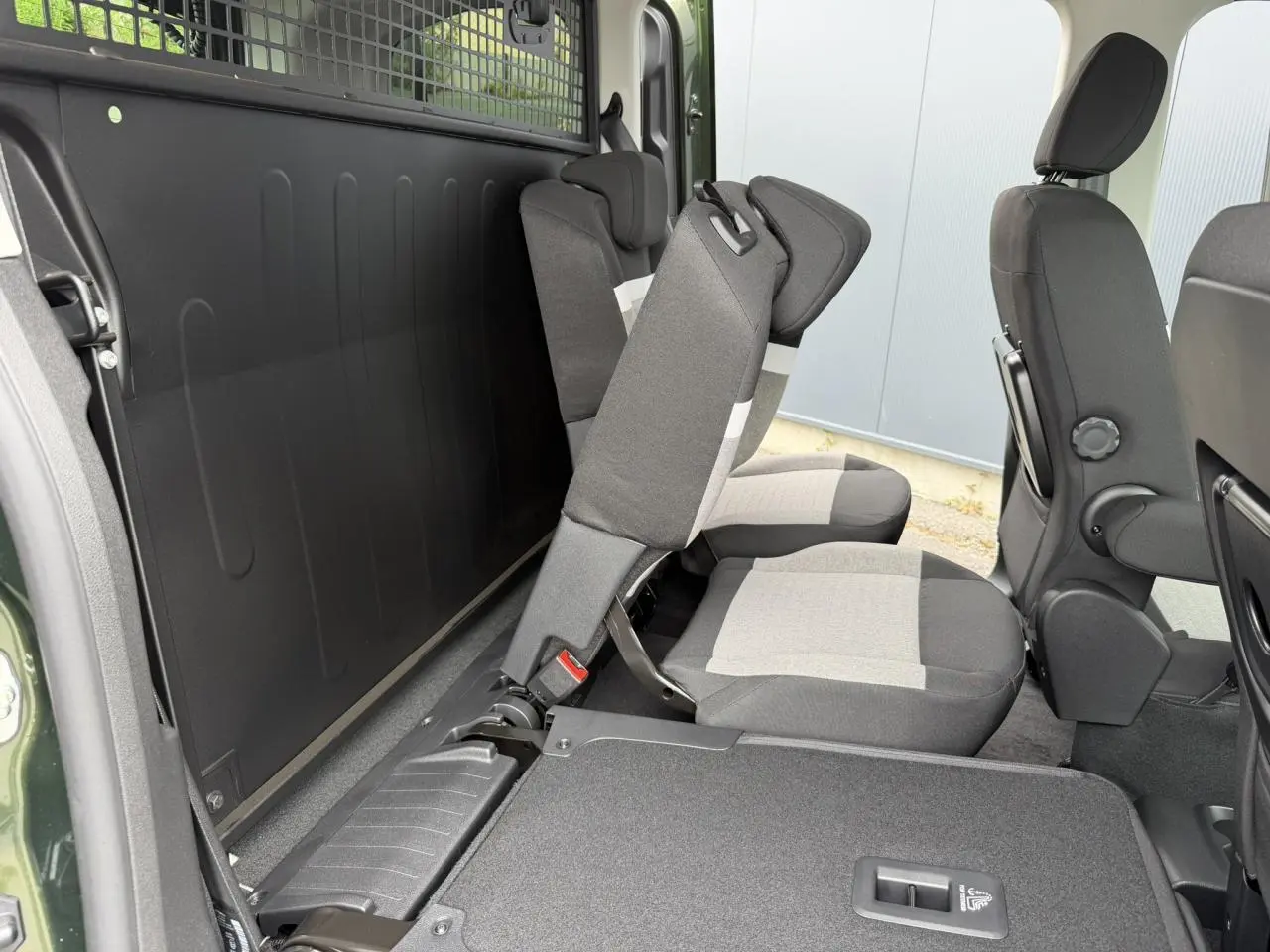 Vue intérieure côté droit du Citroën Berlingo Multispace 2026 vert Sirkka, sièges arrière escamotés et rang 1 en tissu gris.