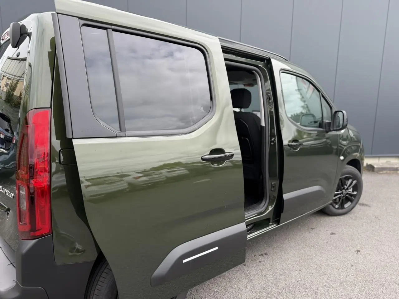 Vue 3/4 arrière droite du Citroën Berlingo Multispace vert Sirkka avec porte coulissante ouverte et vitres surteintées.