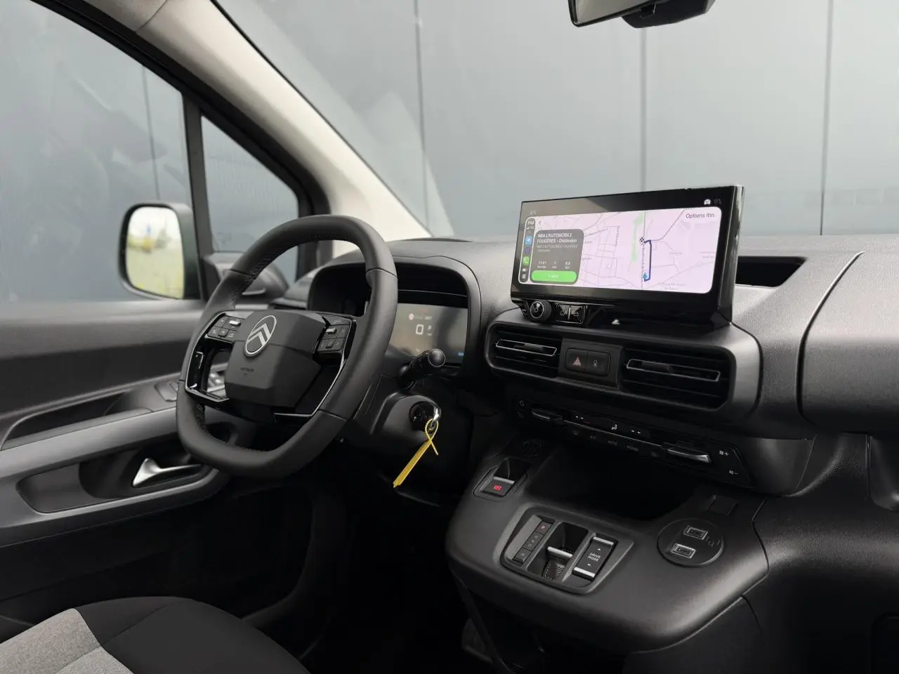 Vue intérieure côté conducteur du Citroën Berlingo Multispace 2026 avec écran tactile et volant multifonctions noir.