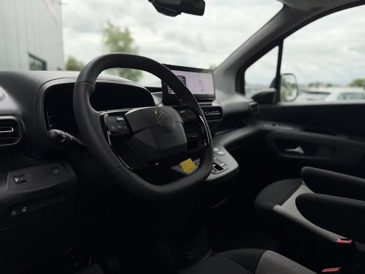 Vue intérieure côté conducteur du Citroën Berlingo Multispace 2026, volant cuir multifonctions et écran tactile GPS visible.