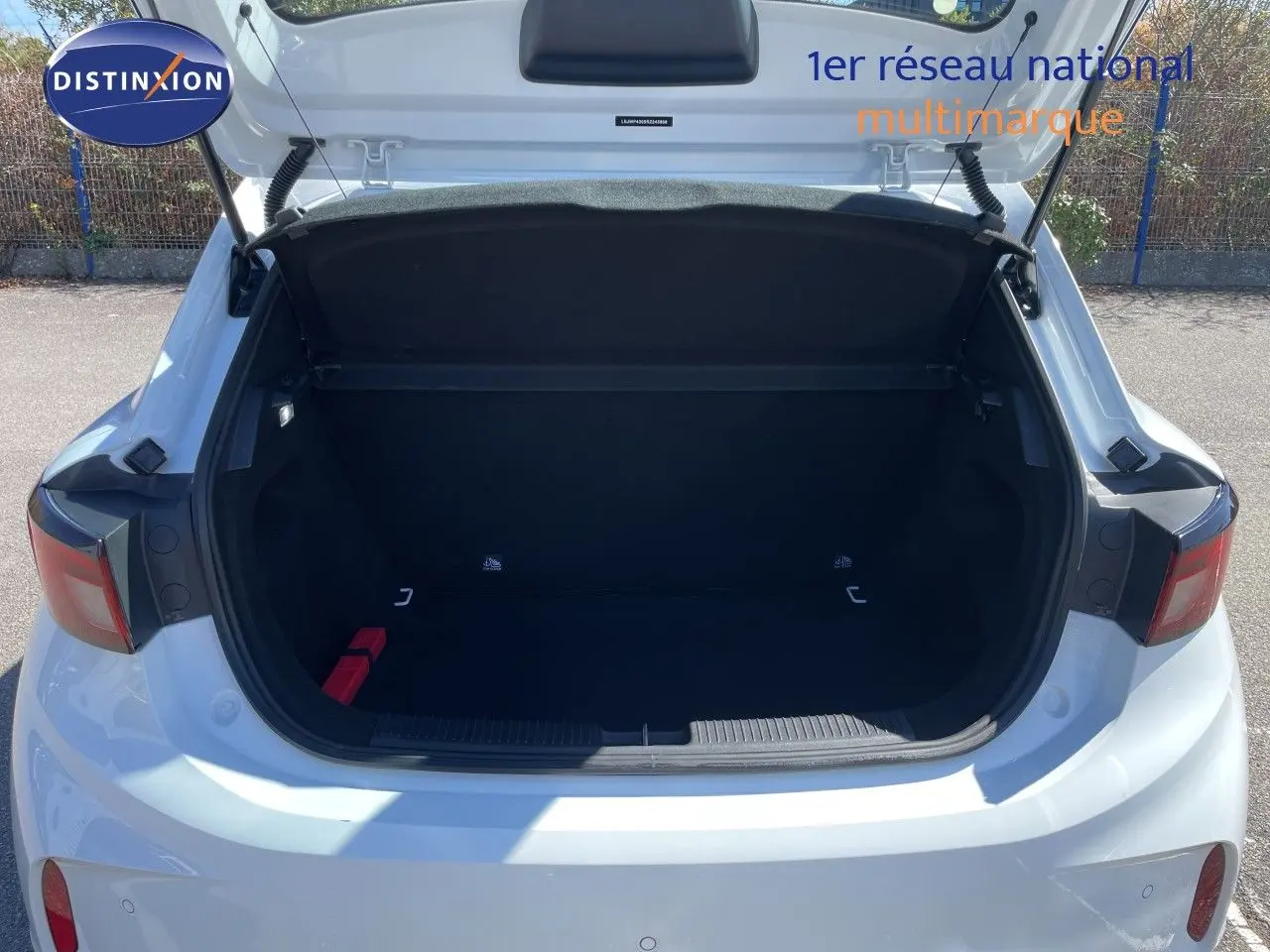 Coffre ouvert vu de l'arrière d'une MG3 1.5L Hybrid+ 195ch Comfort blanche Dover White, avec feux arrière visibles.