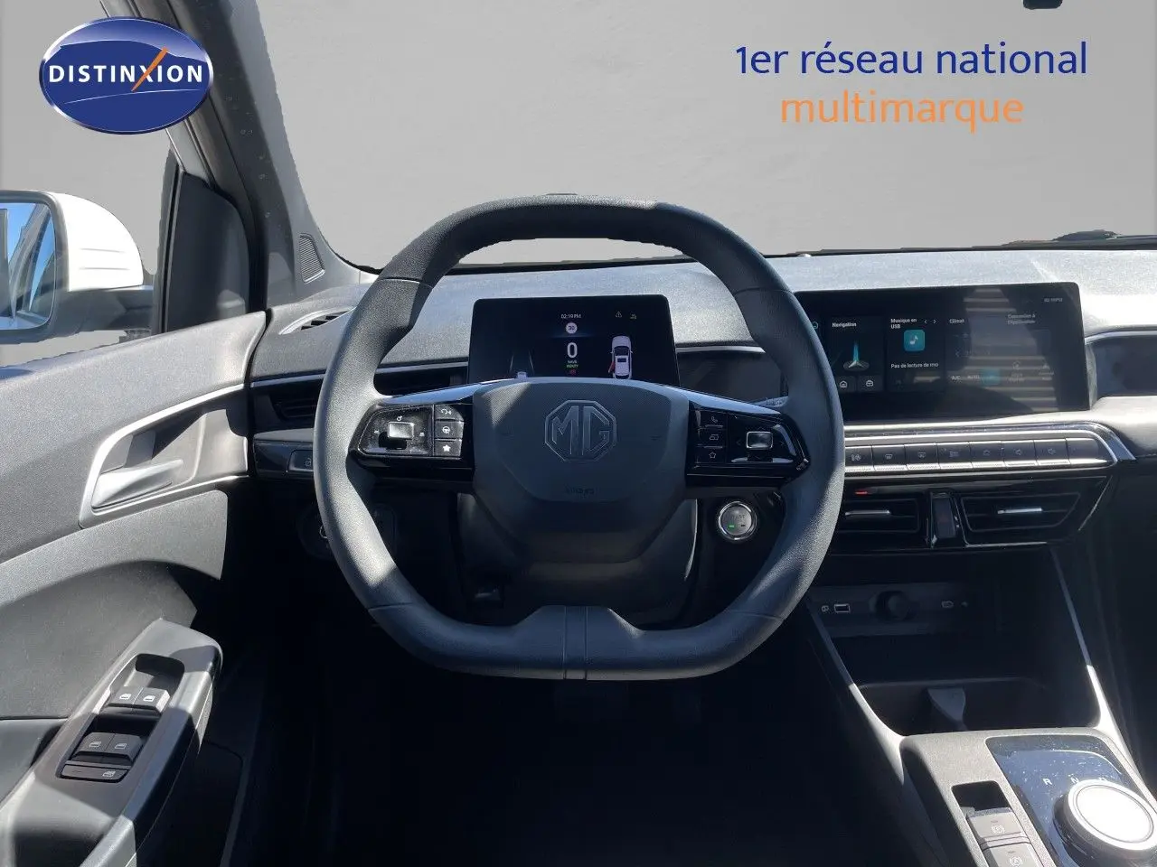 Vue intérieure centrée sur le volant MG d'une MG3 1.5L Hybrid+ blanche, avec tableau de bord digital et écran tactile.