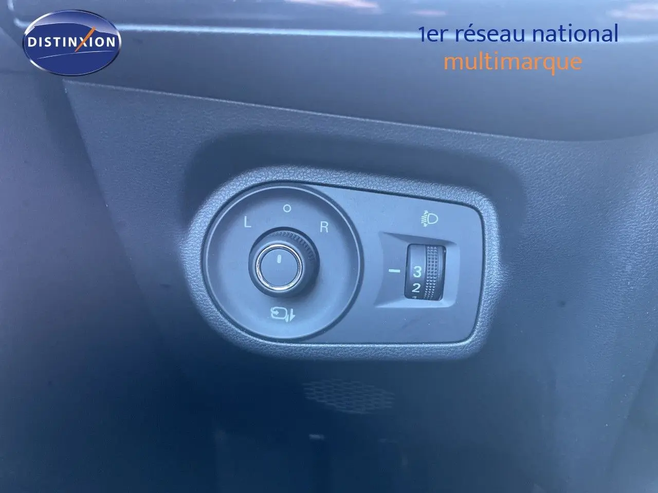 Gros plan sur les commandes de réglage des rétroviseurs et des phares d’un MG3 1.5L Hybrid+ 2025 en intérieur noir.