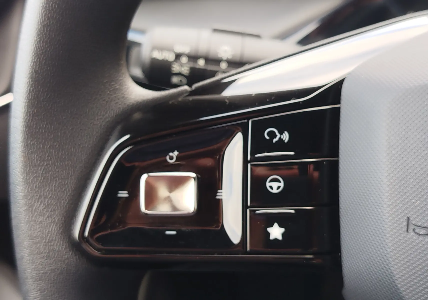 Gros plan sur les commandes multifonctions noires à gauche du volant du MG3 Dover White 2025, avec boutons tactiles et finition brillante.