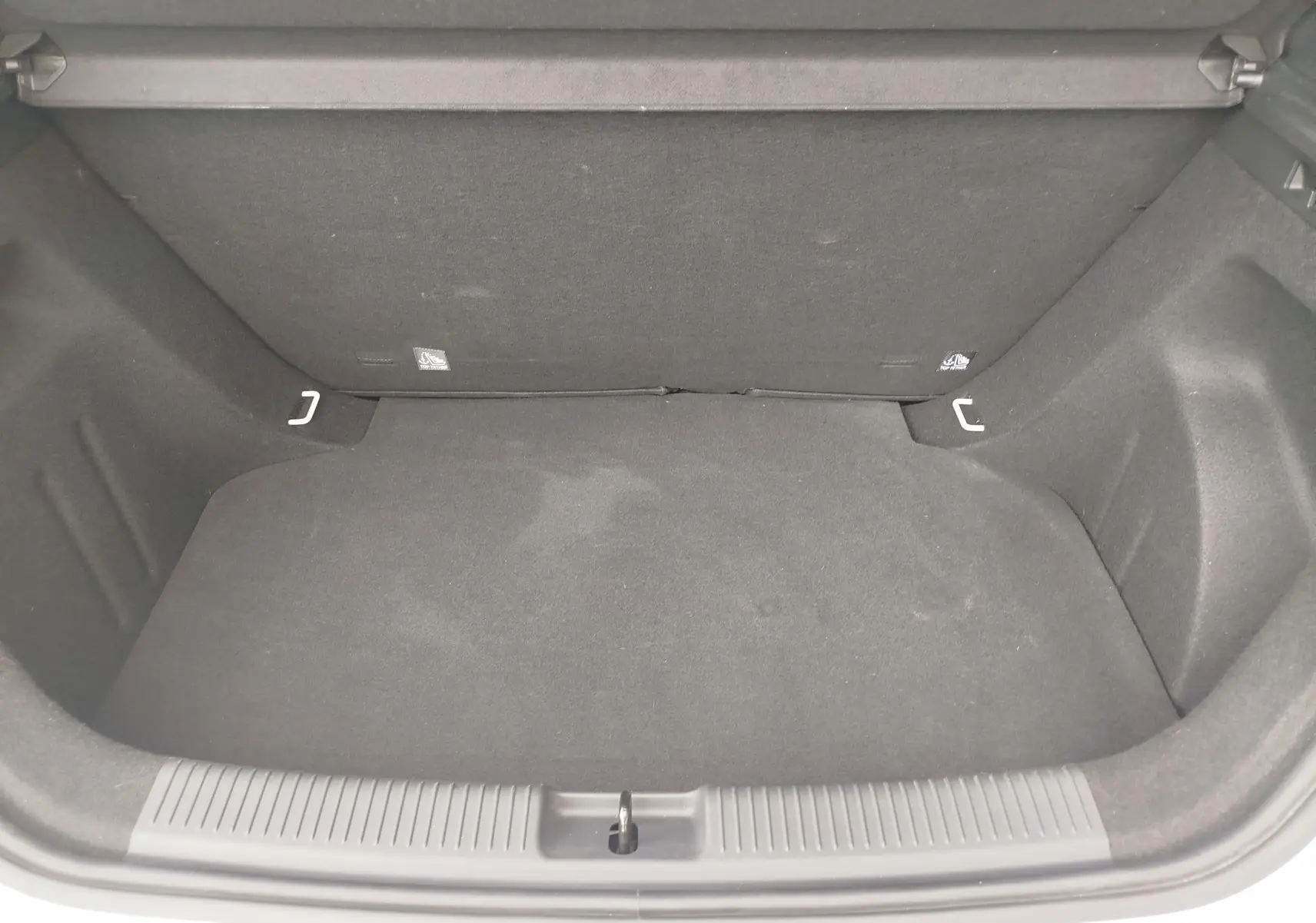 Coffre ouvert vu de face d’un MG3 1.5L HYBRID+ 195CH COMFORT en blanc Dover, intérieur noir et tapis de sol.