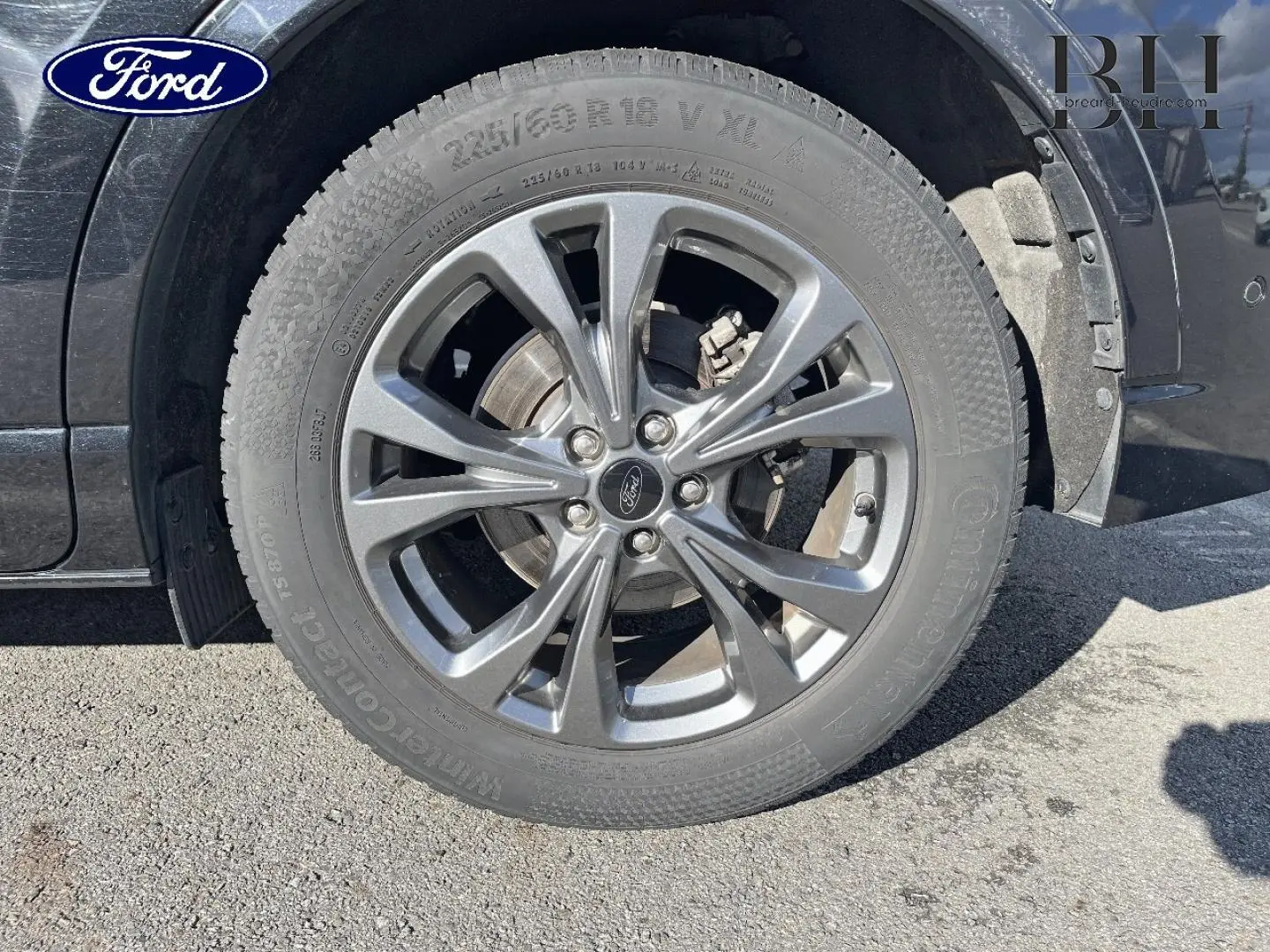 Gros plan sur la jante alu gris foncé et le pneu du côté avant droit d’un Ford Kuga noir Agate Métallisée.