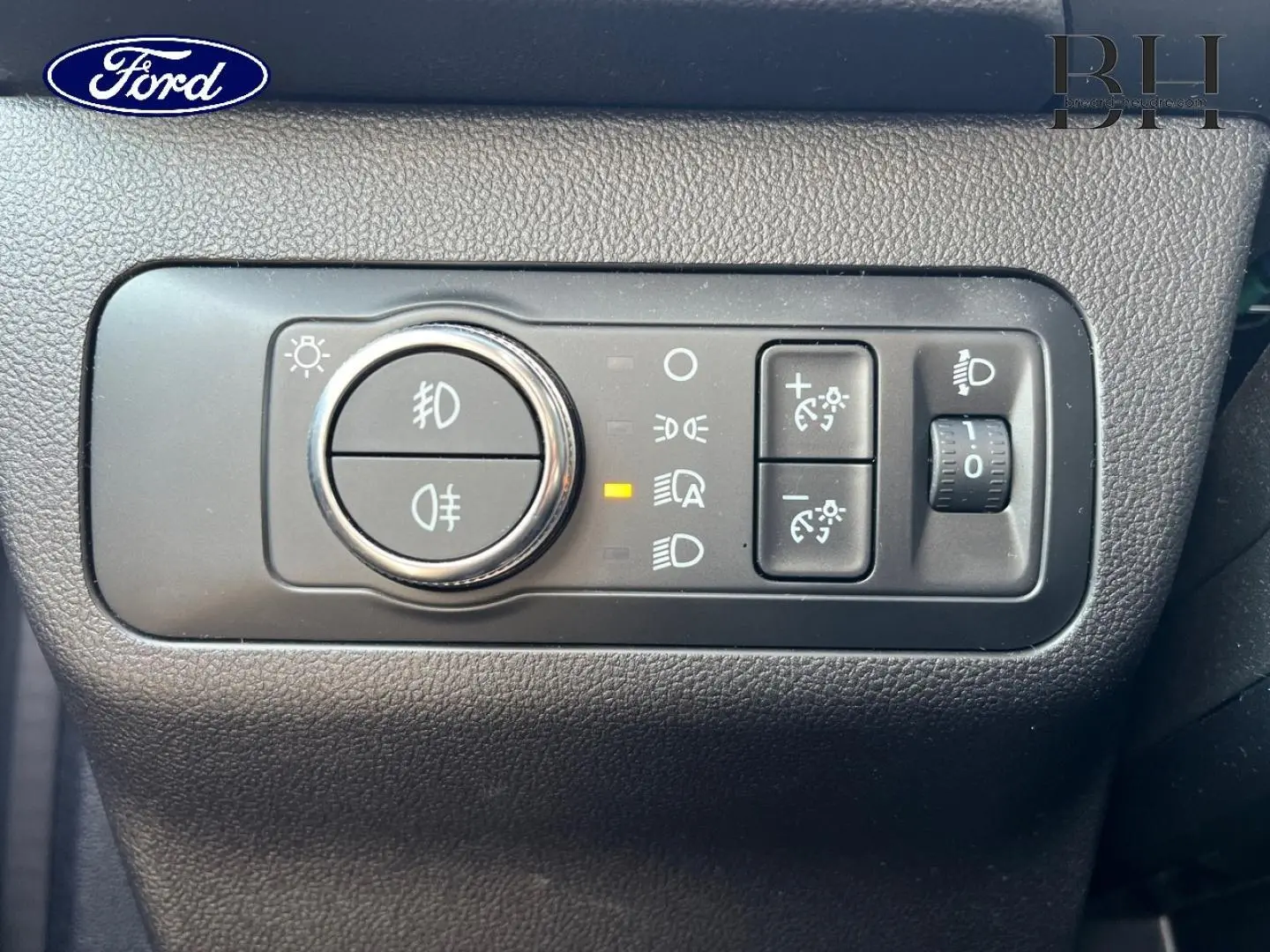 Gros plan sur les commandes d’éclairage intérieures du Ford Kuga 2023, finition ST-Line Business, avec bouton rotatif et réglages lumineux.