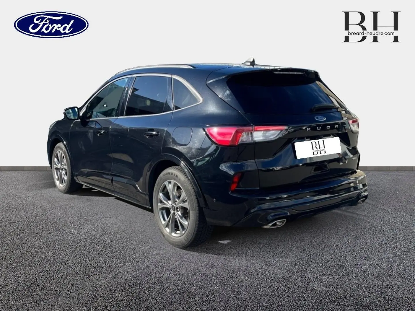 Ford Kuga noir Agate métallisé vu en 3/4 arrière droit, avec vitres arrière surteintées et double sortie d’échappement.