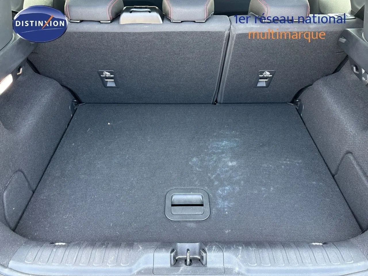 Coffre ouvert vu de l'arrière d'un Ford Puma blanc 2022, montrant l'espace de chargement et les dossiers arrière rabattus.