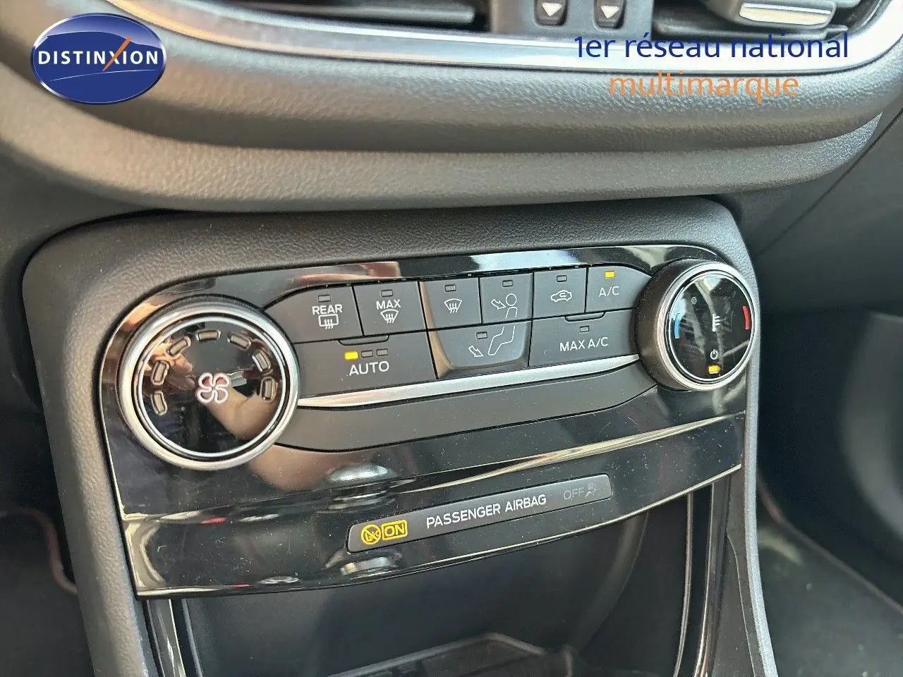 Détail de la console centrale du Ford Puma blanc 2022, mettant en valeur les commandes de climatisation et l'indicateur d'airbag passager.