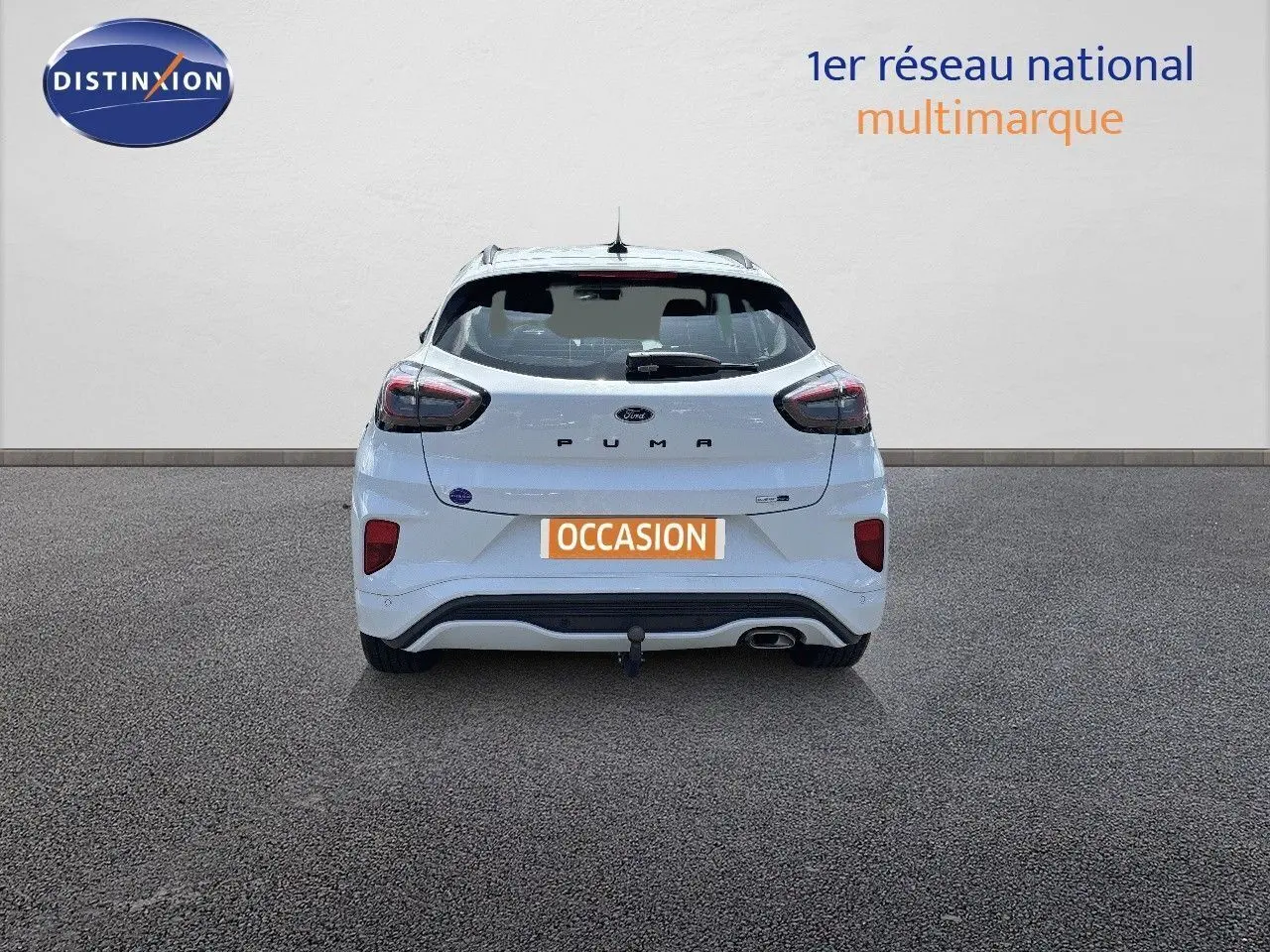 Vue arrière d'une Ford Puma blanche 2022 avec attelage et feux arrière LED, stationnée sur sol gris.
