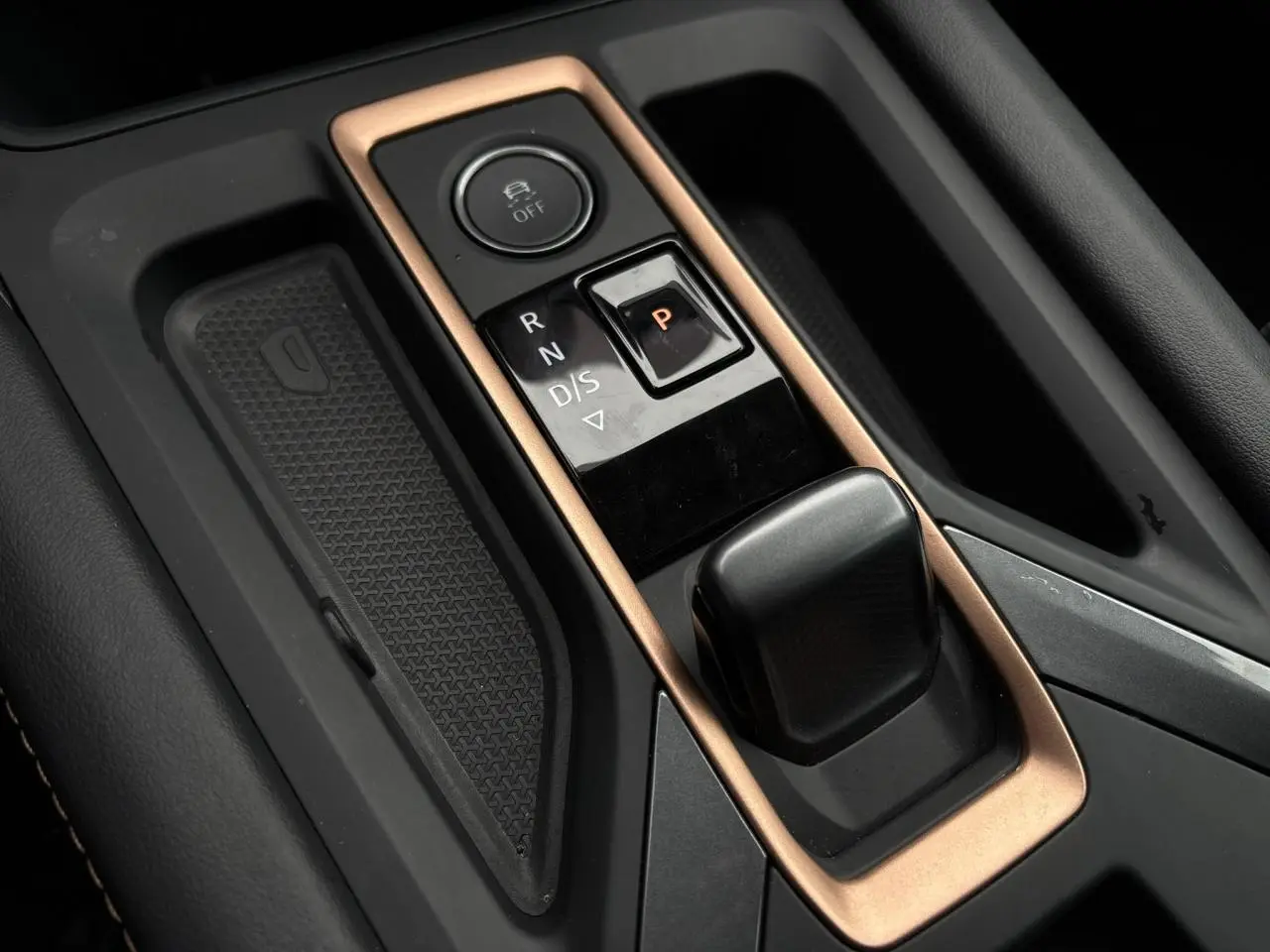 Gros plan sur la console centrale de la CUPRA LEON ST 2025, avec levier de boîte automatique et cadre cuivré.