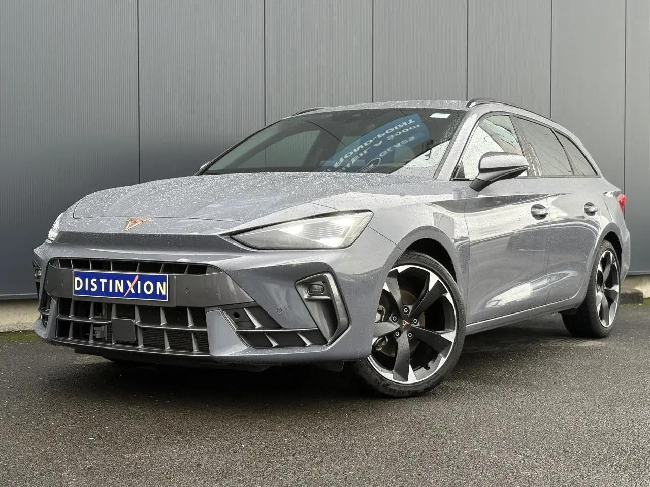 Vue 3/4 avant droite d'une CUPRA Leon ST gris Graphene avec jantes alliage noires et calandre marquée.