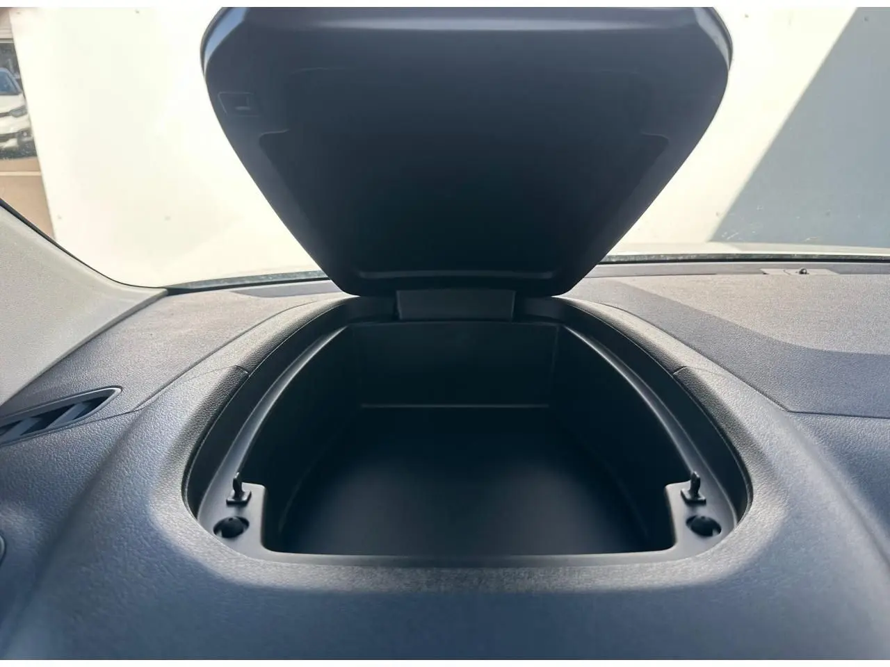 Vue rapprochée du rangement ouvert sur le tableau de bord noir du Citroën Berlingo blanc Icy.