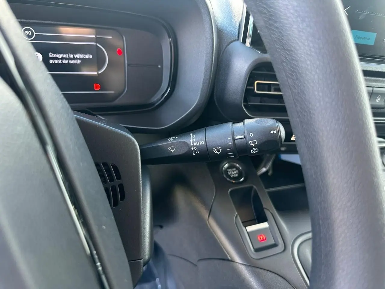 Vue intérieure rapprochée du tableau de bord et du volant du Citroën Berlingo blanc, avec commandes et affichage digital.