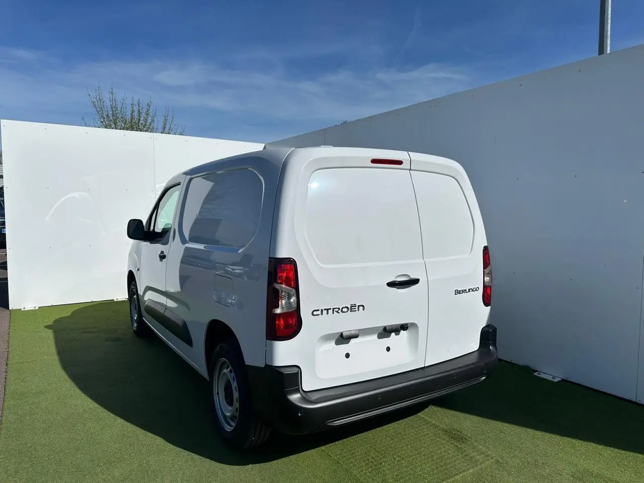 Vue arrière d'un utilitaire Citroën Berlingo blanc Icy avec portes battantes et pare-chocs noir mat.