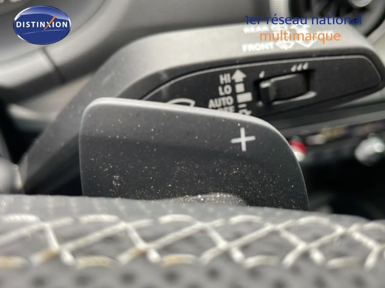 Gros plan sur la palette de changement de vitesse "+" du volant cuir noir de l'Audi Q2 2025 finition S-Line.