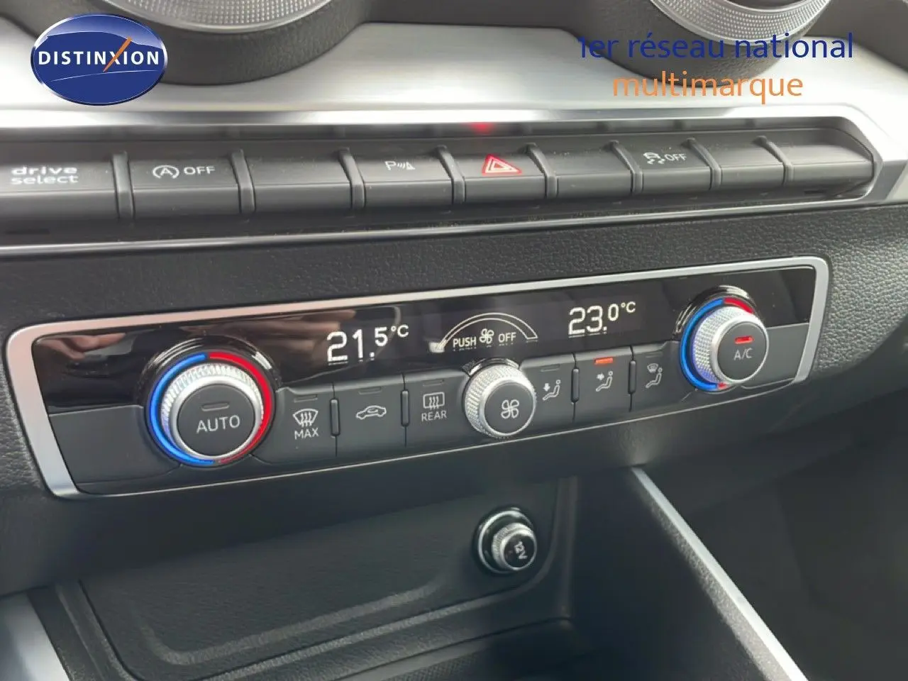 Vue rapprochée de la console centrale de l'Audi Q2 noire, mettant en valeur les commandes de climatisation digitale et boutons fonctionnels.