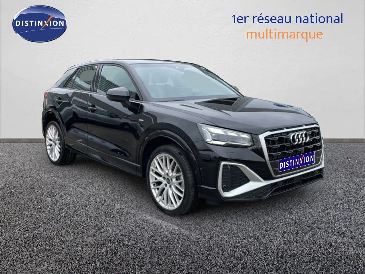 Audi Q2 noir mito metal en 3/4 avant droit, mettant en valeur sa calandre hexagonale et ses jantes alliage argentées.