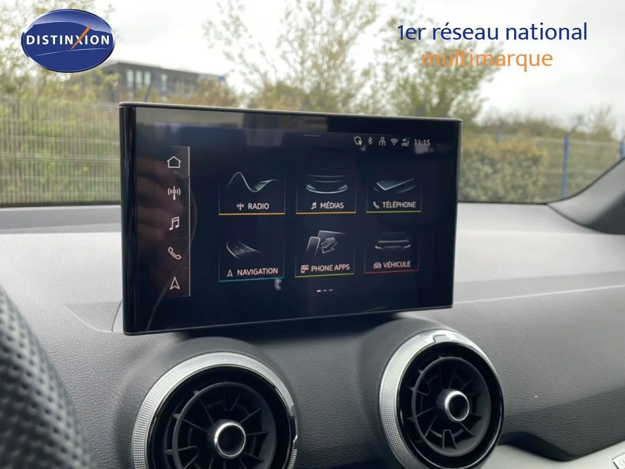 Écran tactile central et aérateurs ronds du tableau de bord intérieur d’un Audi Q2 noir mito metal.