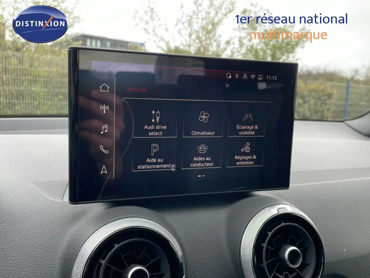 Écran tactile central affichant les options du véhicule dans l'habitacle d'un Audi Q2 noir mito metal, vue intérieure frontale.