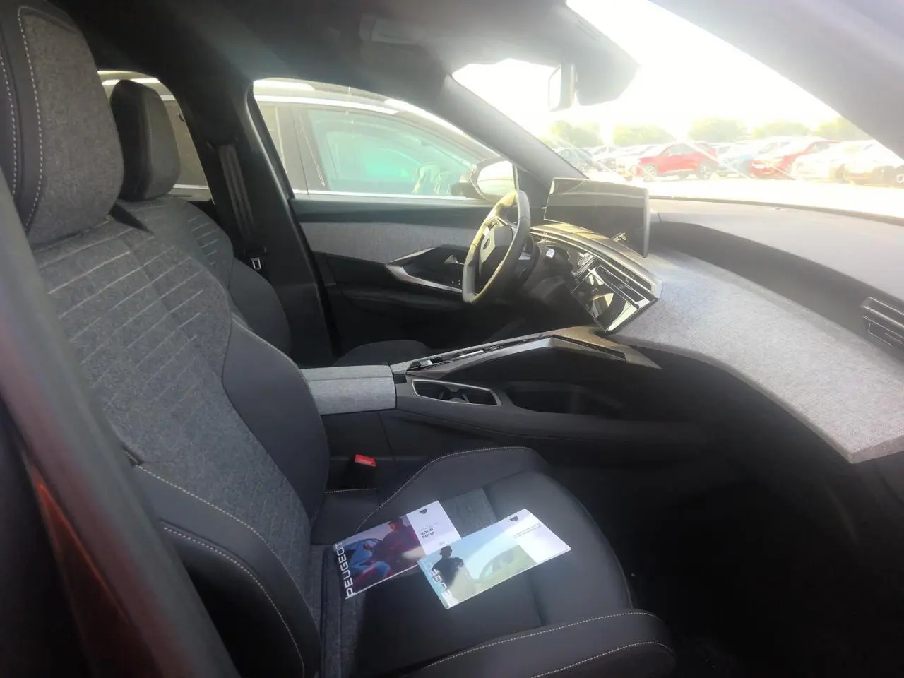 Vue intérieure côté conducteur du Peugeot 5008 gris foncé, mettant en valeur le tableau de bord et l’écran incurvé panoramique.