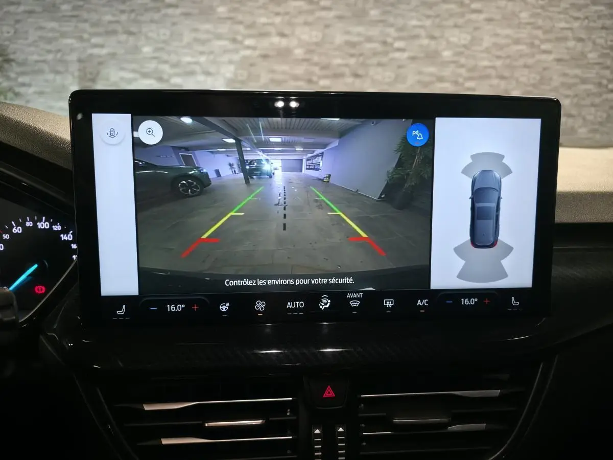 Écran tactile intérieur montrant la caméra de recul et l'aide au stationnement de la Ford Focus noire 2024.