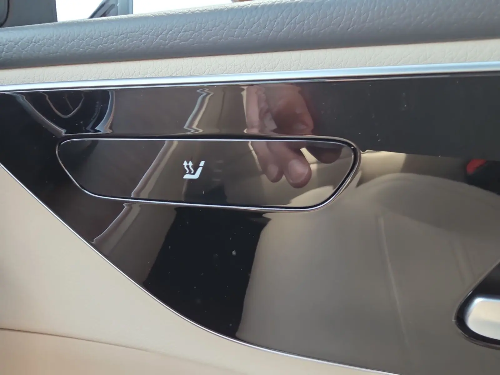 Bouton de siège chauffant sur panneau de porte intérieur beige et noir d'une Mercedes Classe C Break 220 D 4MATIC.