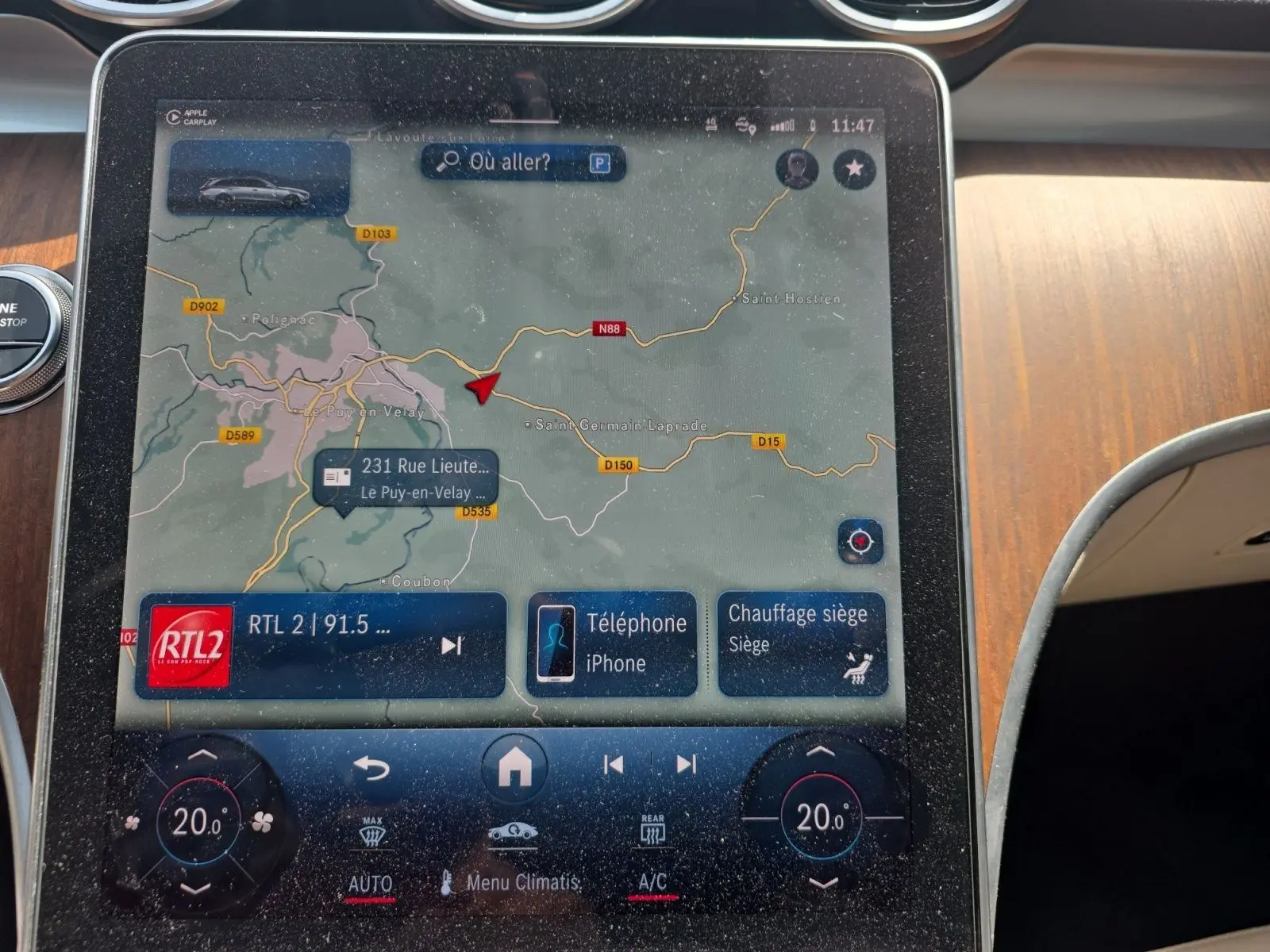 Écran tactile du système de navigation et climatisation dans le break Mercedes Classe C gris foncé, vue intérieure centrale.