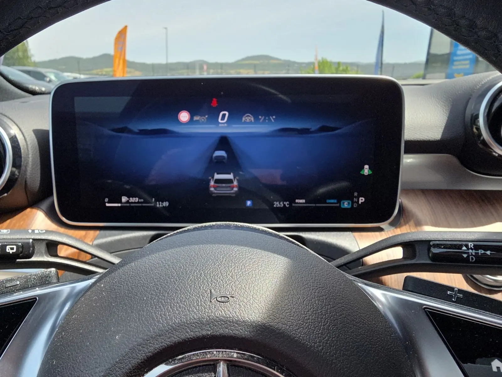 Vue intérieure centrée sur le volant et l'écran numérique du cockpit virtuel d'une Mercedes Classe C Break gris foncé.