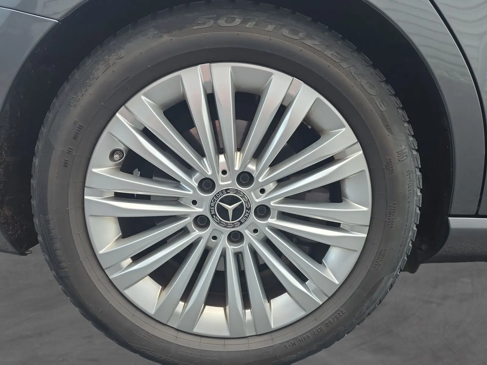 Gros plan sur la jante alliage 17” argentée d’un Mercedes Classe C Break gris foncé, mettant en valeur le logo central.