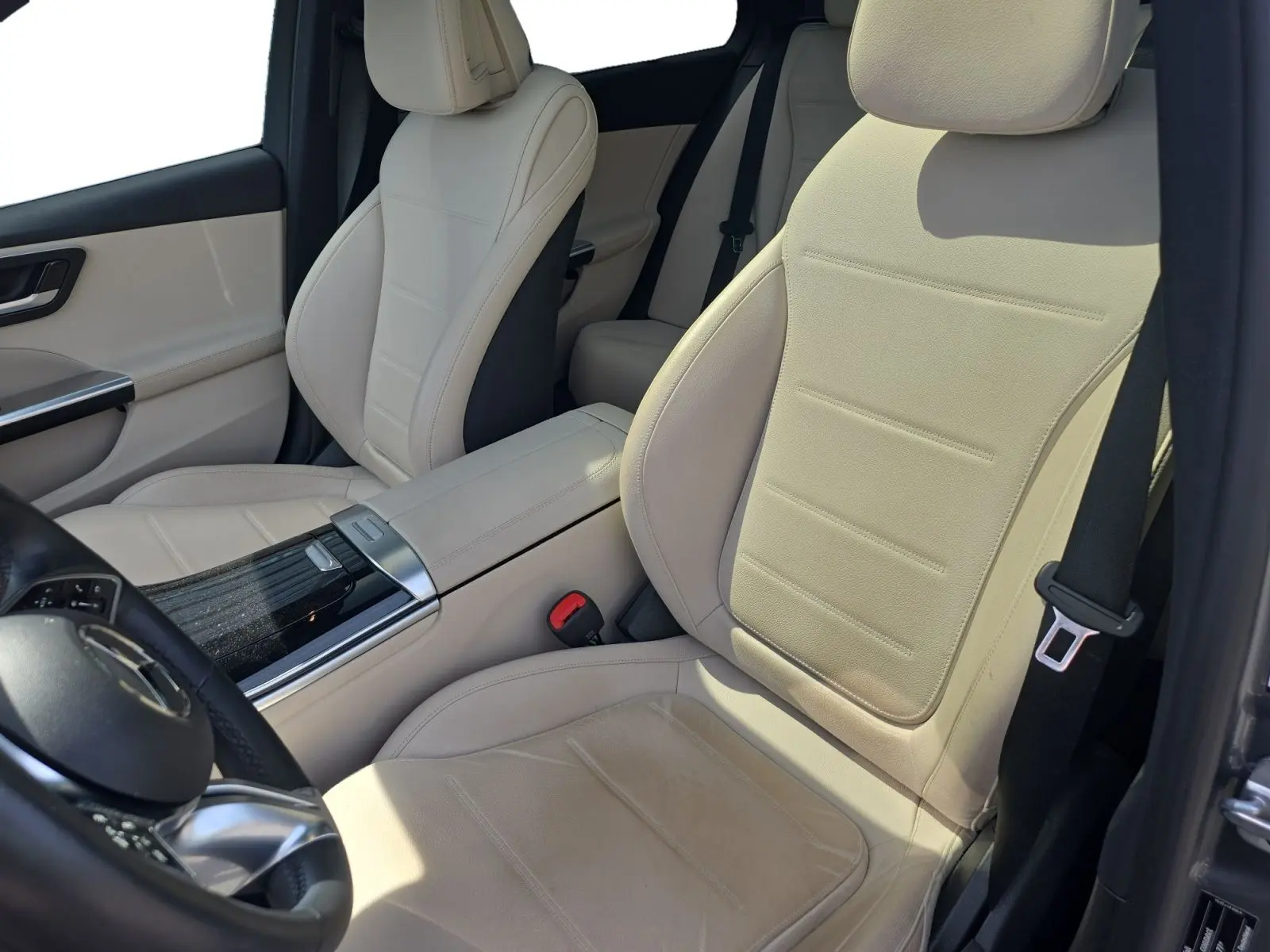 Vue intérieure côté conducteur de la Mercedes Classe C Break 220 D 4MATIC avec sellerie cuir beige et console centrale noire brillante.