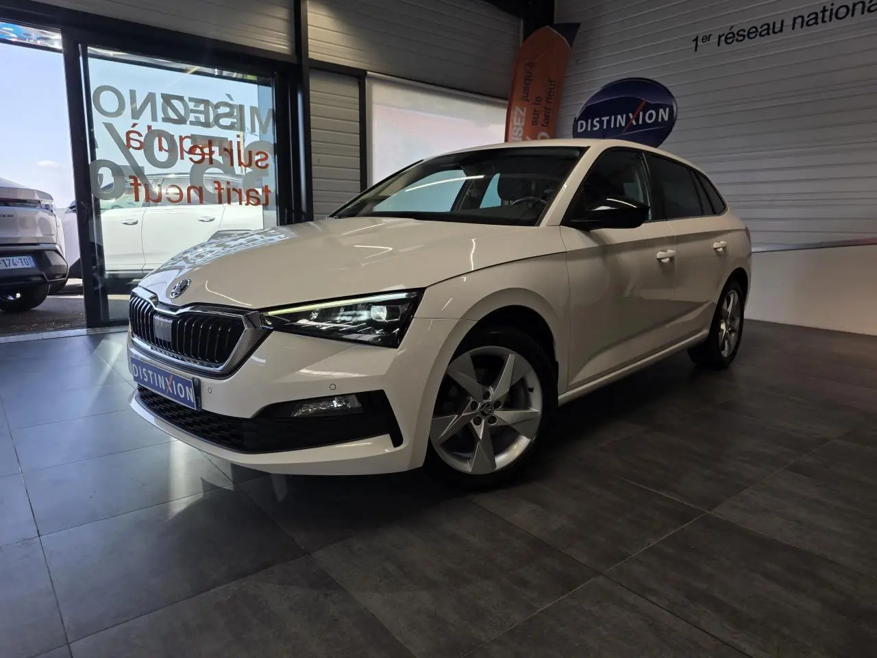 Vue 3/4 avant droite d'une Skoda Scala blanche avec jantes alliage et calandre chromée en showroom.