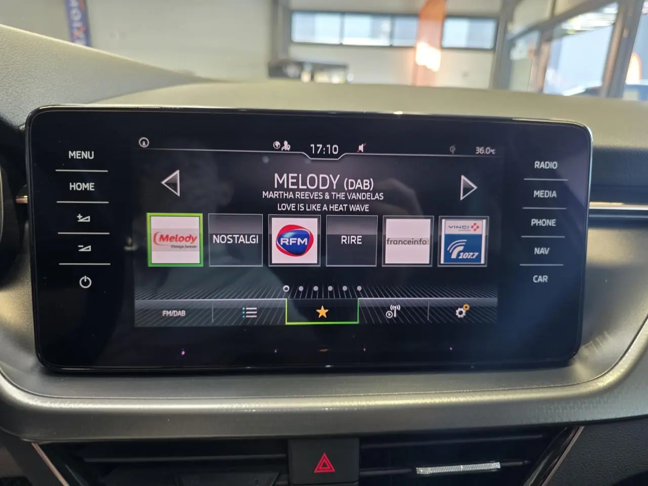 Écran tactile central du tableau de bord d'une Skoda Scala blanche, affichant les stations radio numériques.
