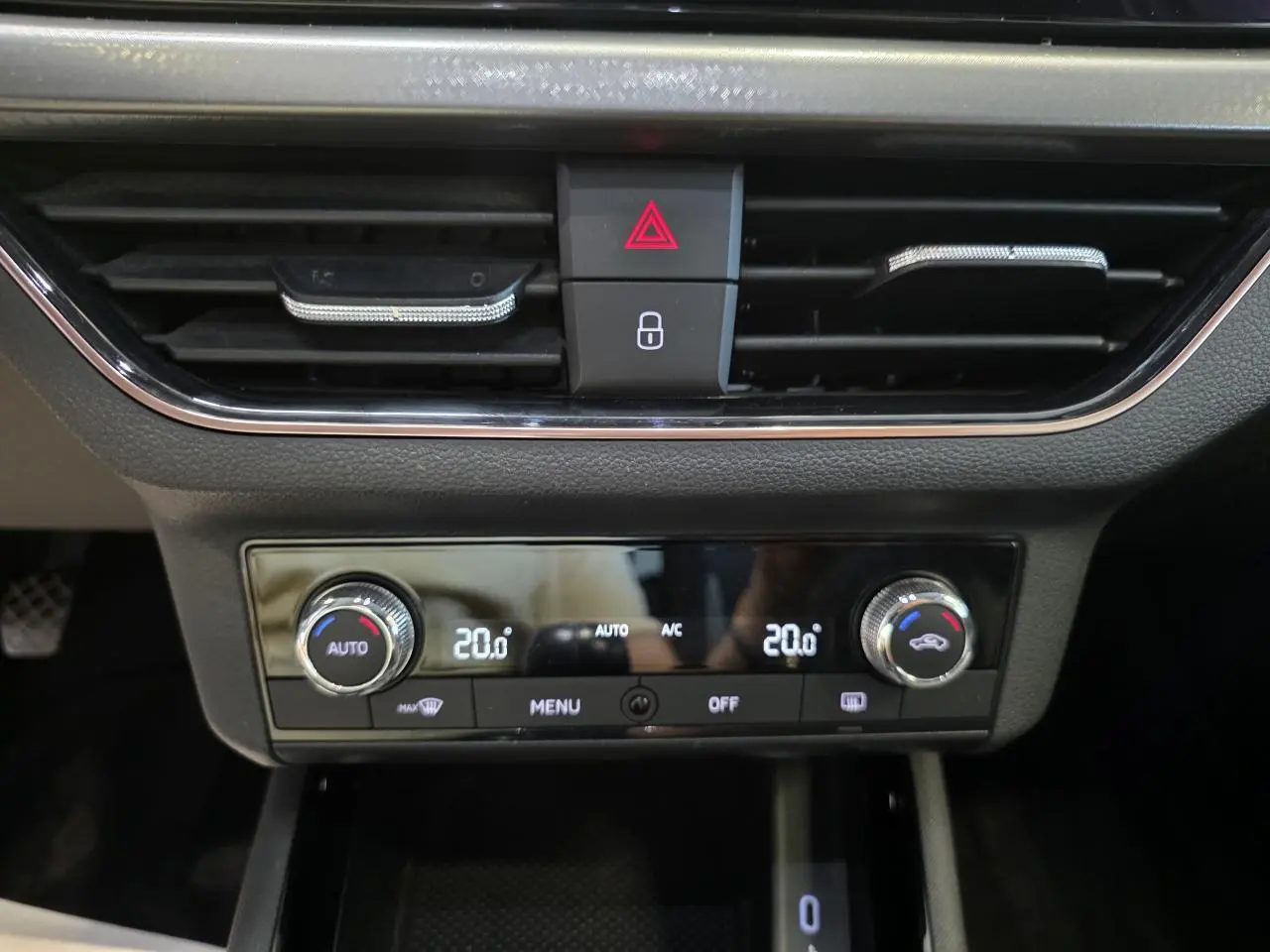 Détail de la console centrale noire avec climatisation automatique bi-zone et commandes digitales sur Skoda Scala blanche.