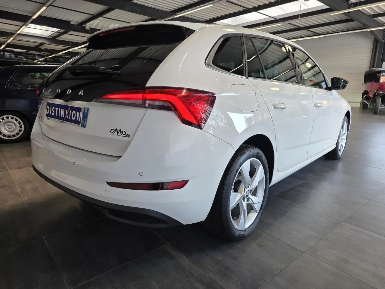 Vue 3/4 arrière droite d'une Skoda Scala blanche avec feux arrière LED et jantes alliage argent.